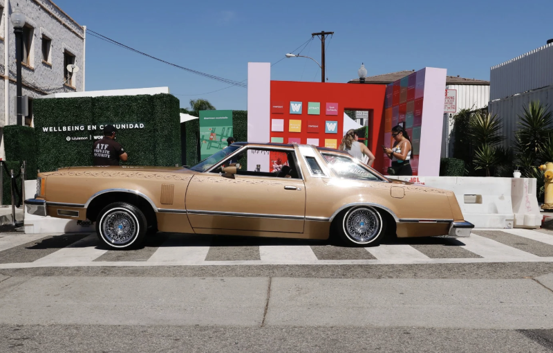 Gold lowrider parked in front of the Wellbeing en Comunidad activation