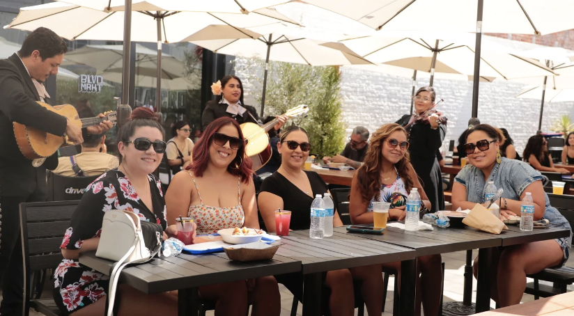 Mariachi performing live on the BLVD MRKT patio while friends share a table