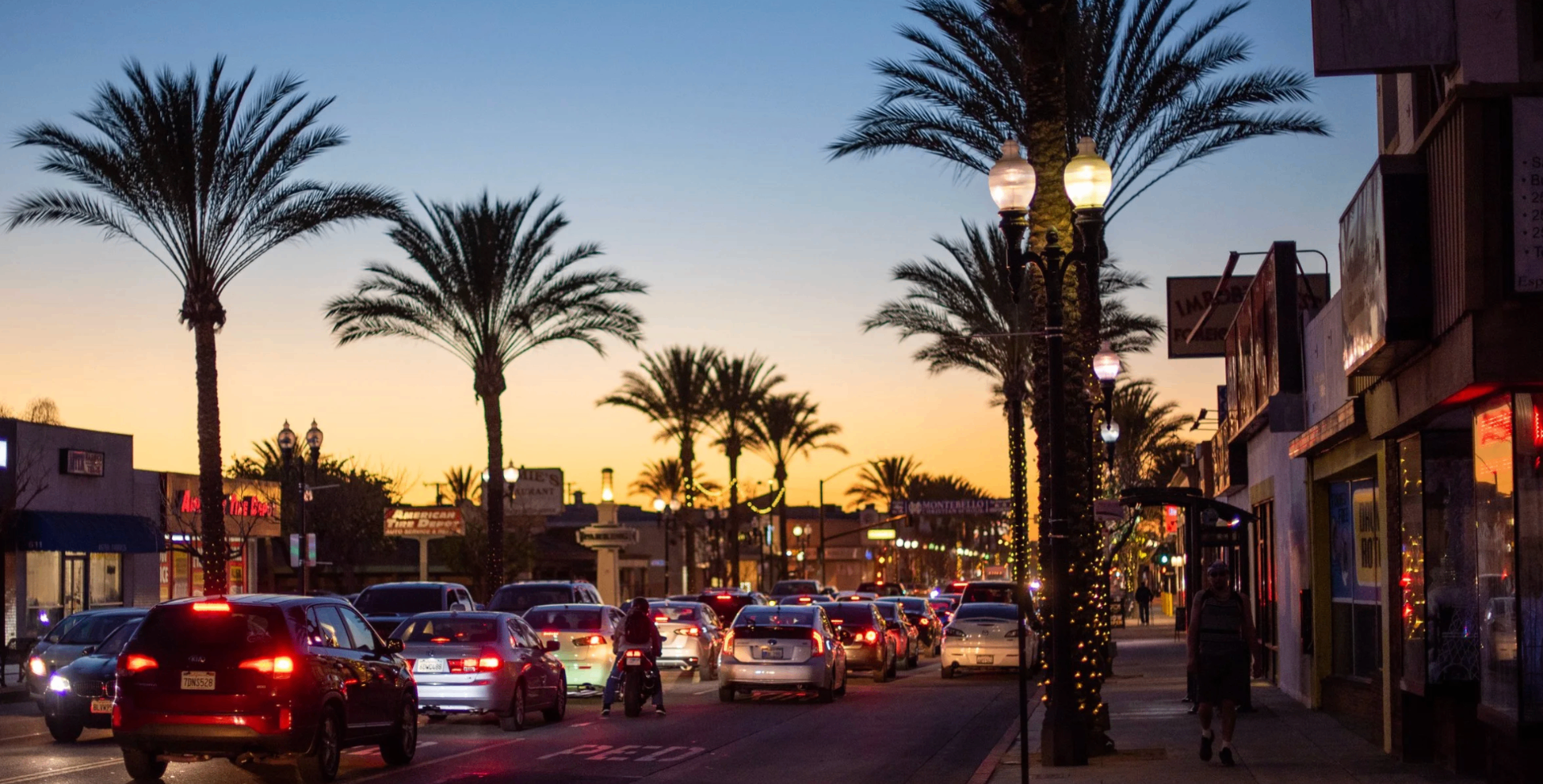 Whittier Boulevard at golden hour, palms silhouetted against the sky