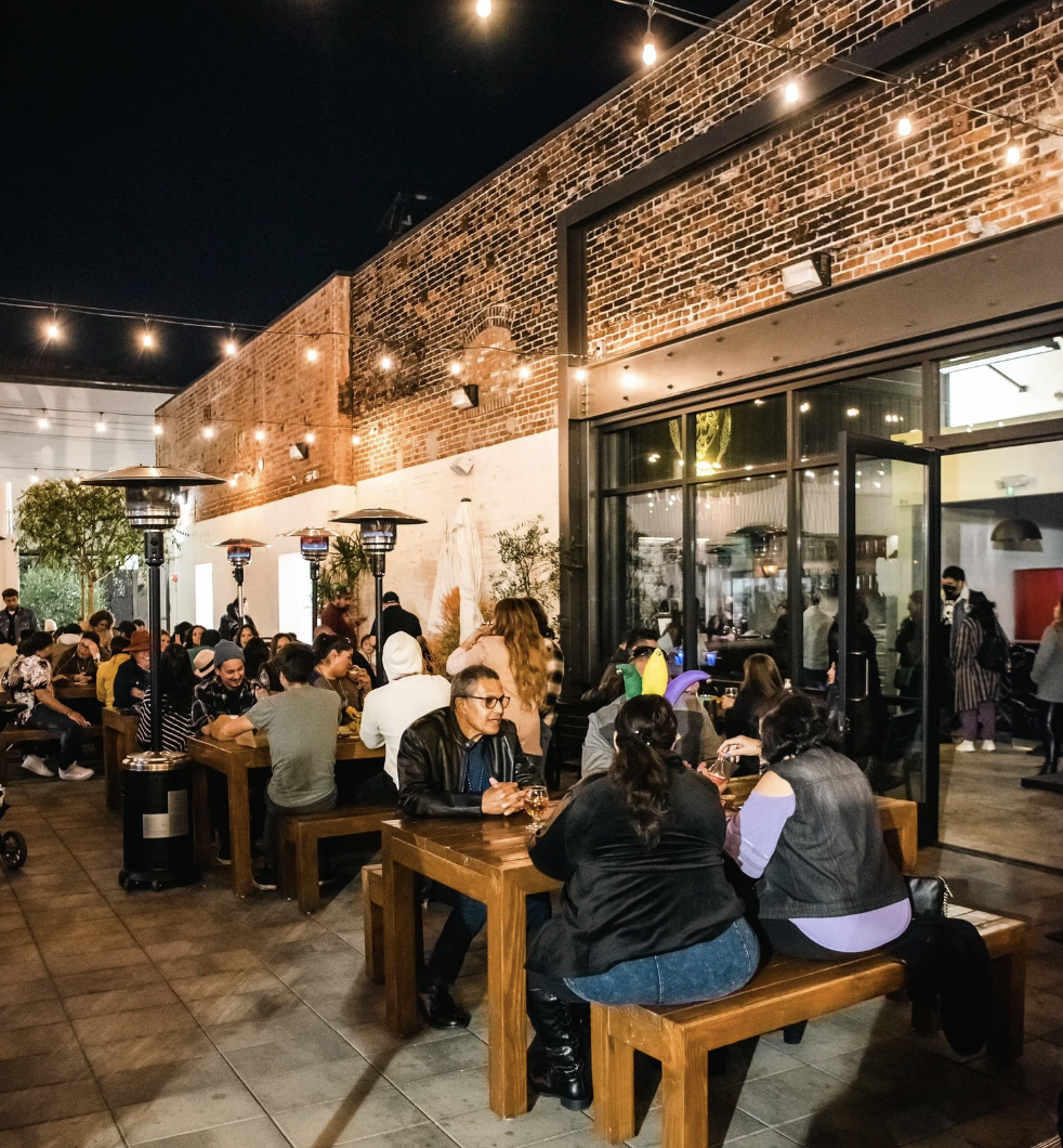 BLVD MRKT patio at night with string lights and full tables